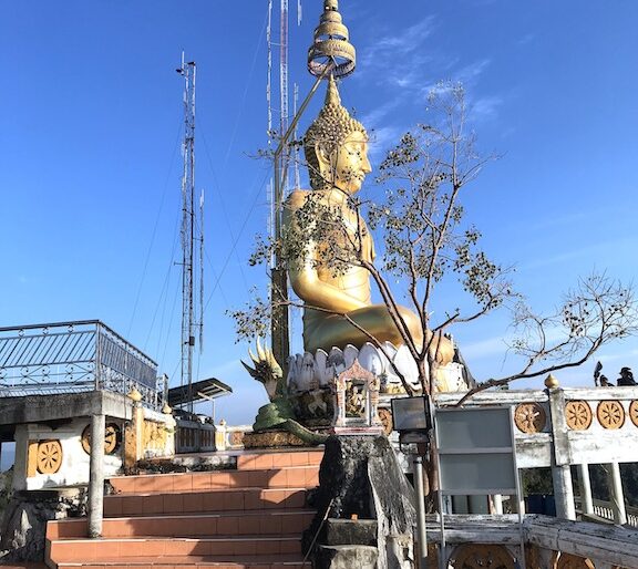 The massive Buddha statue sitting cross-legged and receiving a gentle breeze at Wat Tham Seua